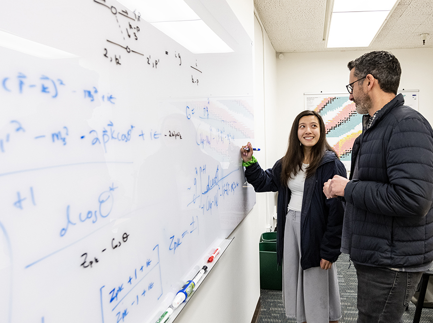 Intern and mentor have a discussion at a white board