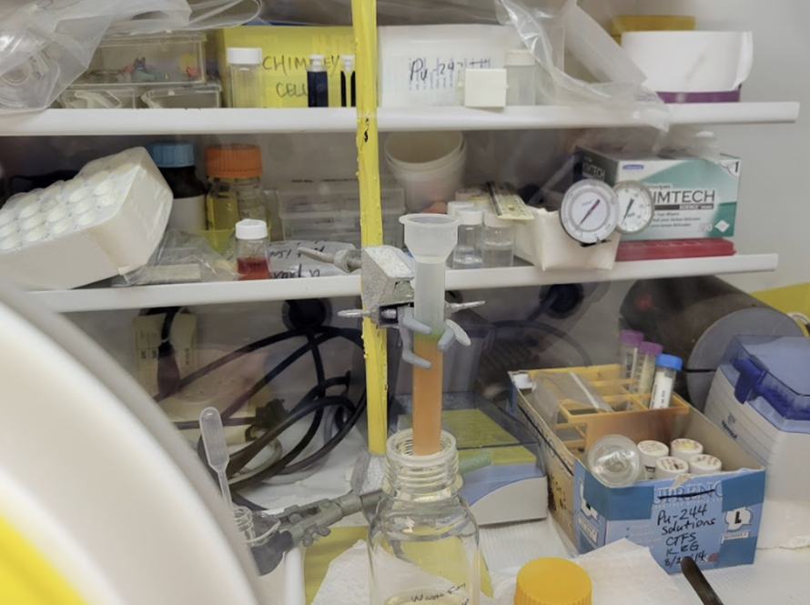 Slightly disheveled lab equipment on table and shelves.