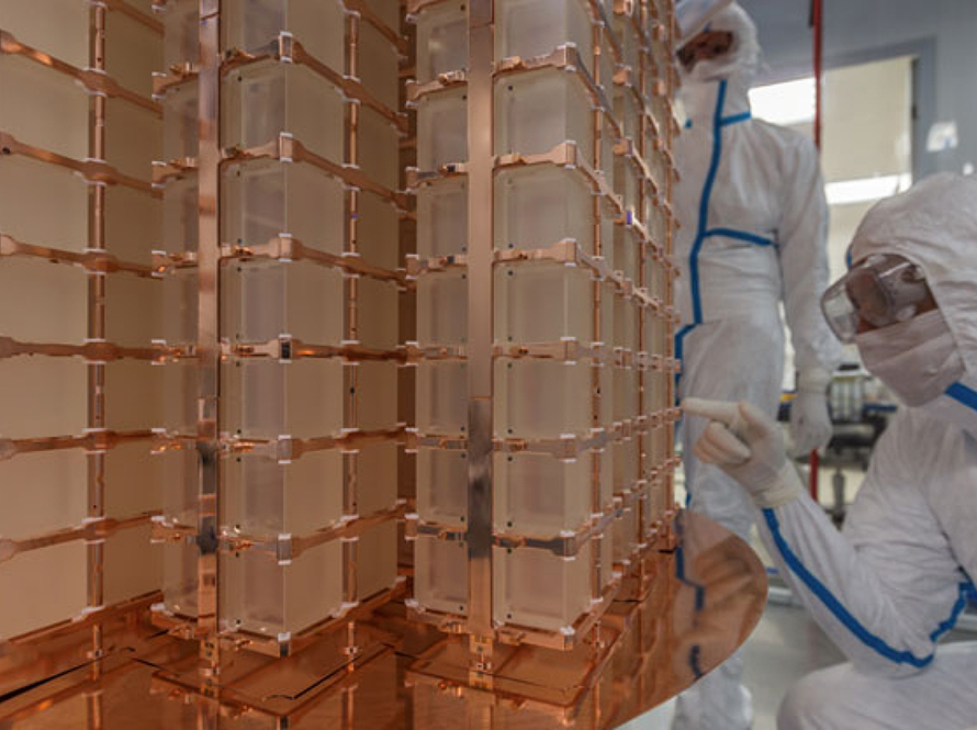 Researchers in clean-room suits examine the CUORE detector.