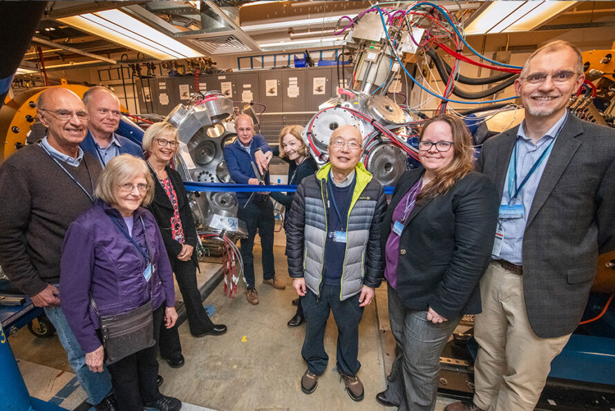 A group of people standing in front of a piece of scientific equipment.