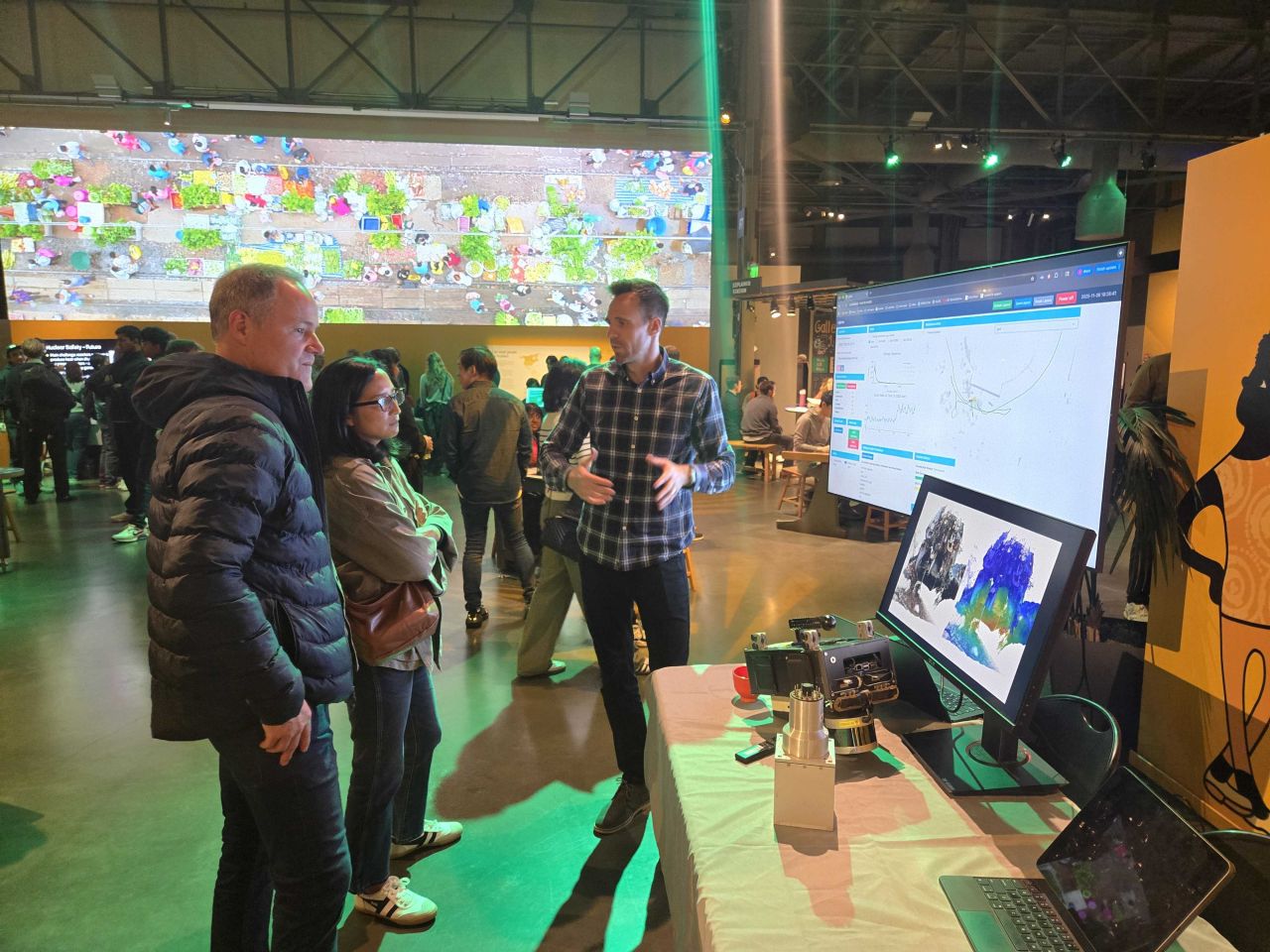 3 people standing in front of multiple displays showing radiation imaging technologies.