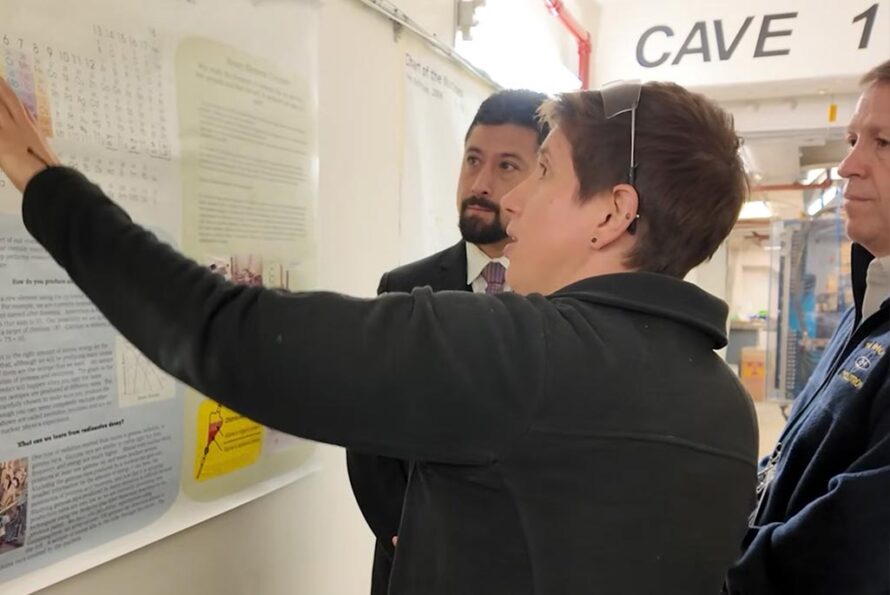 3 people stand in front of a scientific poster