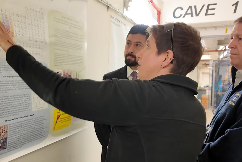 3 people stand in front of a scientific poster