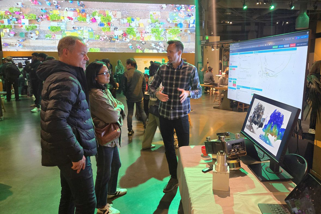 3 people standing in front of multiple displays showing radiation imaging technologies.