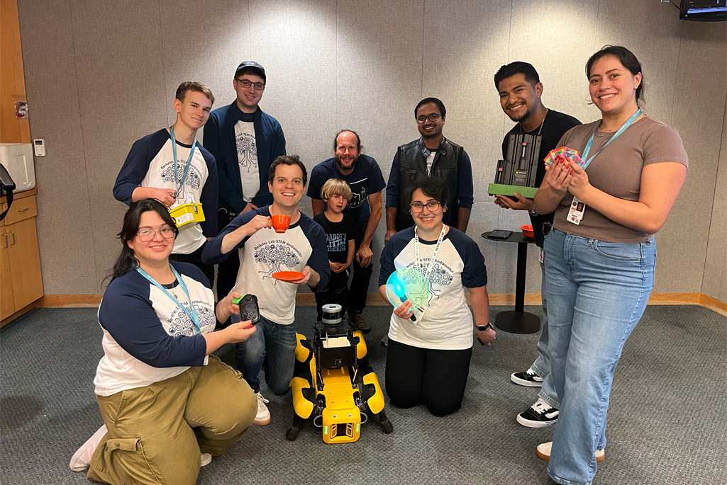 A group of people crowded around a robot dog.