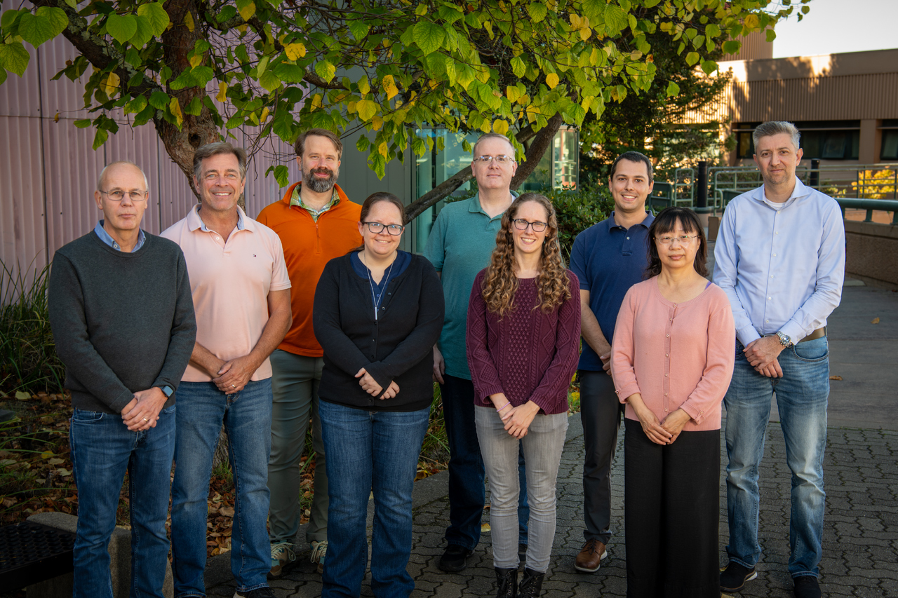 9 People standing in front of a tree