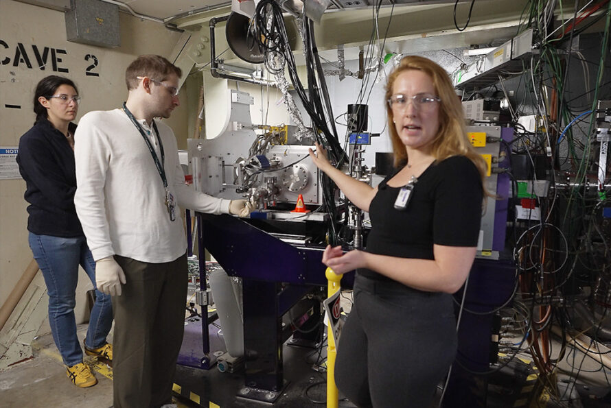 Nuclear Science Division postdoc Marilena Lyklardopoulou (left) and Chemical Sciences Division graduate student Mirza Grebo (center) make adjustments as Jennifer Pore (right foreground), a researcher in Berkeley Lab's Nuclear Science and Chemical Sciences Divisions, shows viewers the FIONA spectrometer at the Lab's 88-Inch Cyclotron.