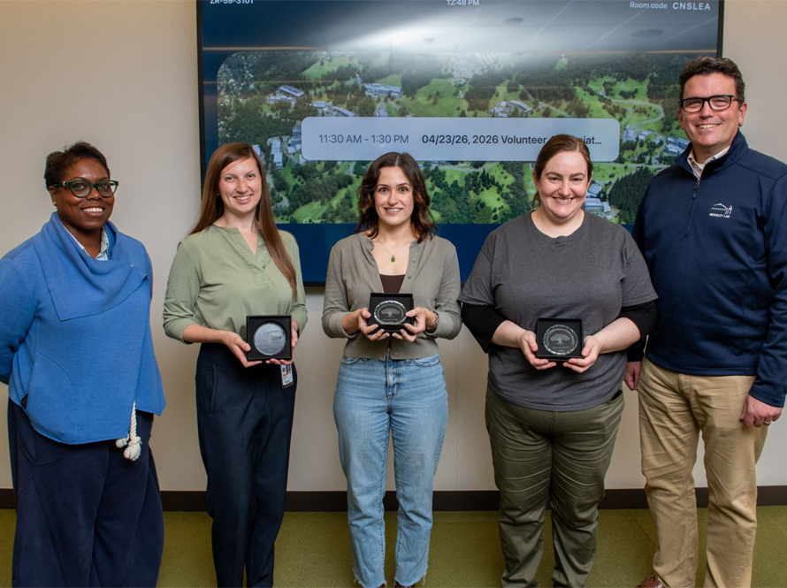 A group of people standing holding awards.